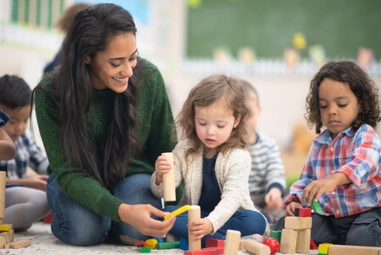 Professora observando crianças pequenas para definir objetivos observáveis no planejamento da Educação Infantil